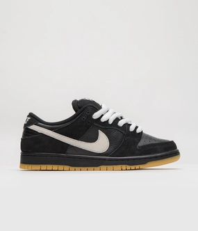 Nike SB Dunk Low Pro Shoes - Black / White - Black - Gum Light Brown - Black running with a headband