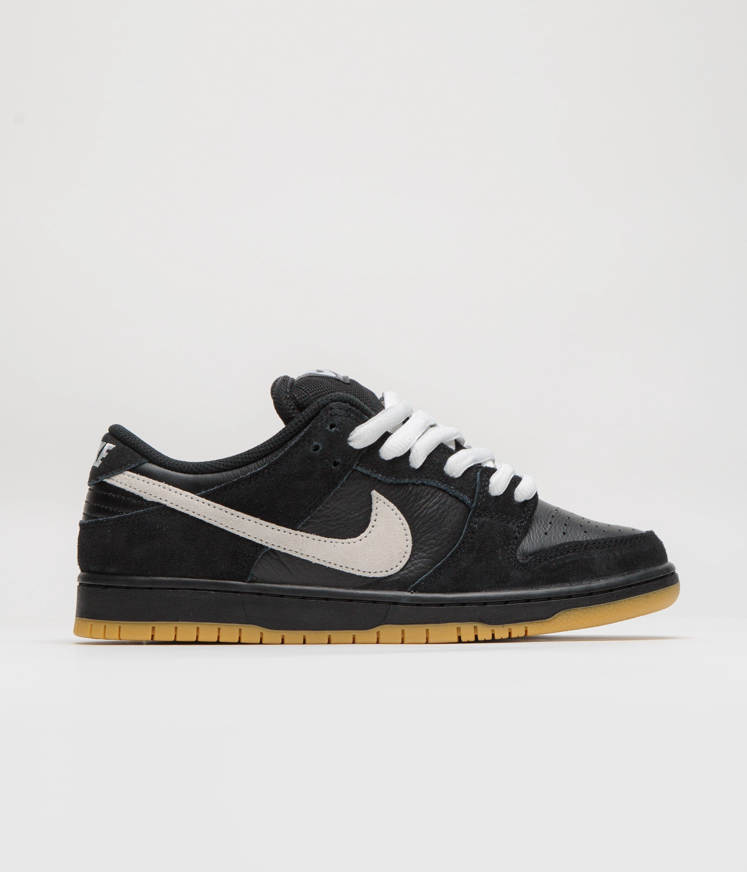 Nike SB Dunk Low Pro Shoes - Black / White - Black - Gum Light Brown - Black running with a headband